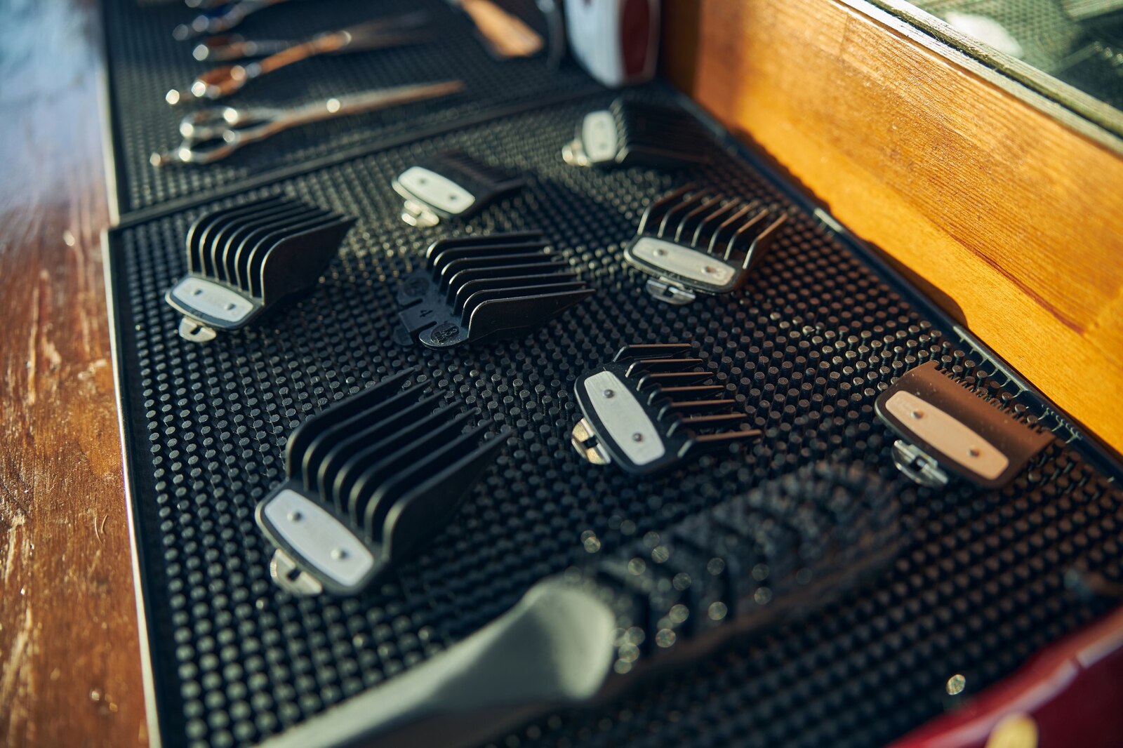 Clean hair clipper guards laid out in a row on a barbershop table.