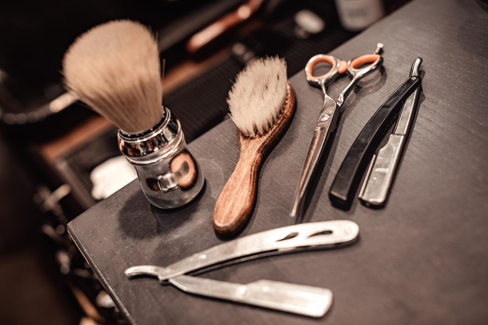 An assortment of barber shop tools including clippers, scissors, combs and a brush.